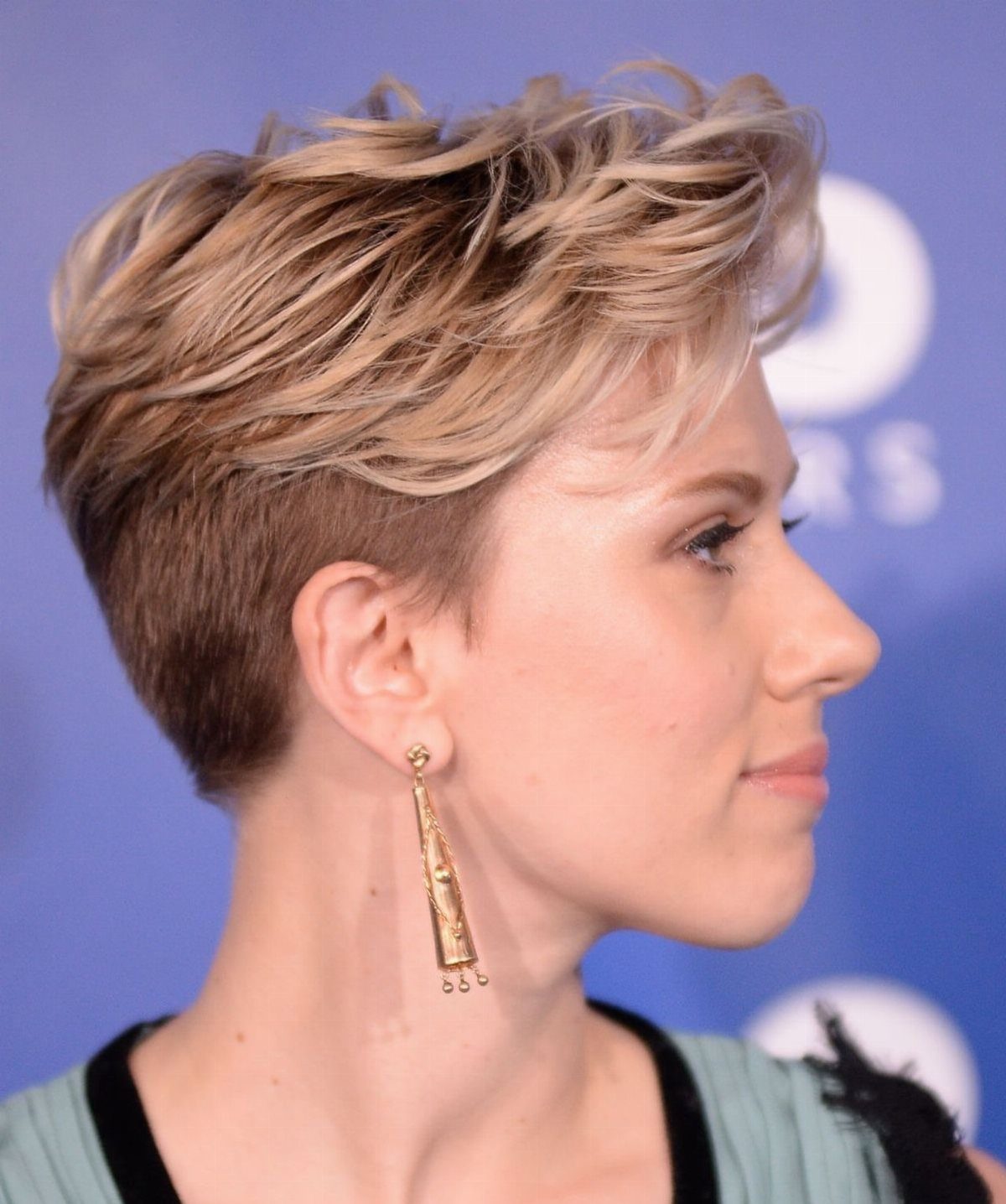 Woman showing a voluminous layered long pixie haircut with tapered sides