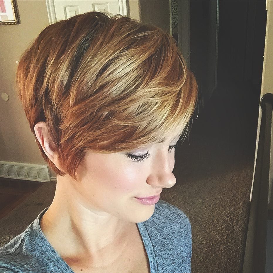 Woman with a piecey auburn pixie cut and sweeping blonde-highlighted layers