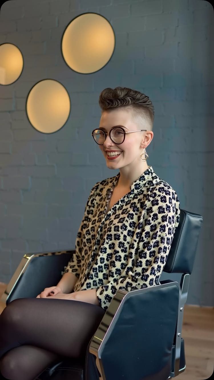Woman seated in salon chair showing a wavy undercut pixie hairstyle
