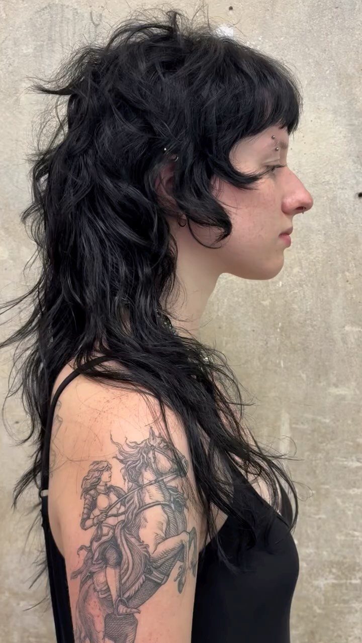 Profile of a person with tousled, layered black long shag and grown-in fringe