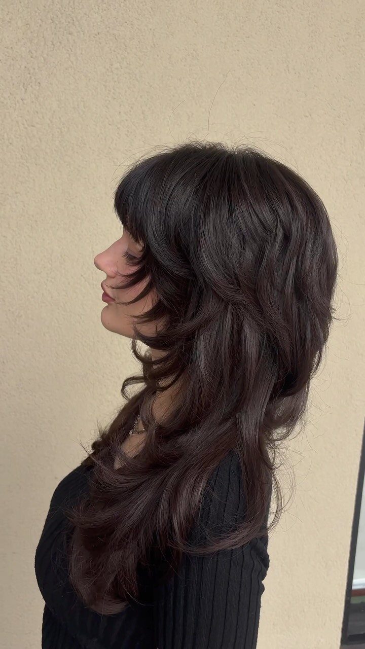 Profile showing long dark shag layers curving around the face and jaw