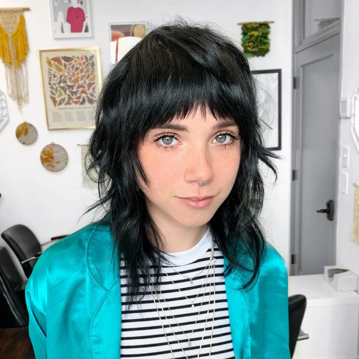 Person with a relaxed, layered black long shag haircut and wispy bangs