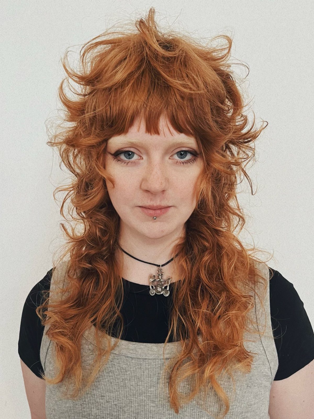 Long copper-red shag with tousled waves and short bangs on a person