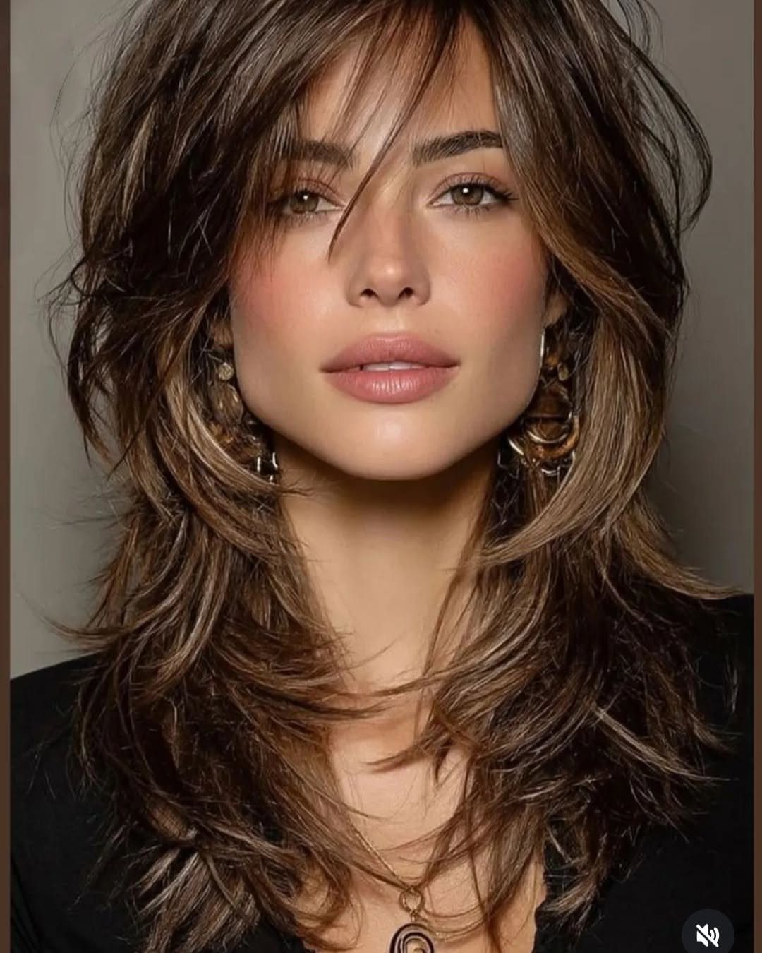 Woman posing with long dark shag layers and outward-flipped hair ends