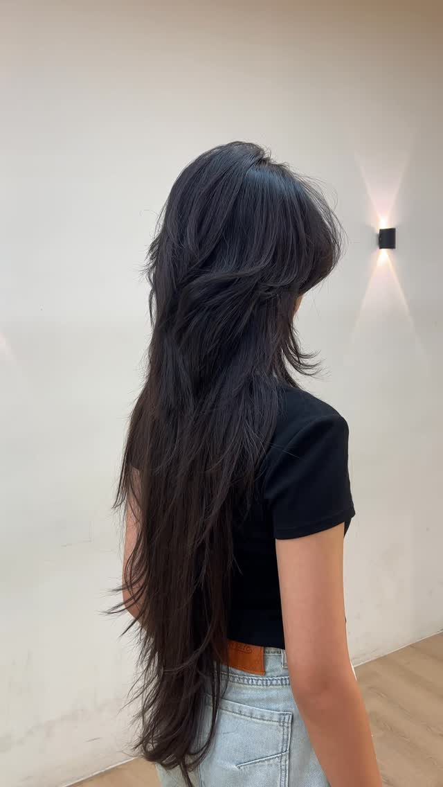 Long dark shag haircut with layered, separated ends viewed from behind