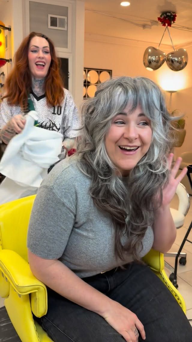 Woman showing a textured silver shag haircut with light, piecey bangs