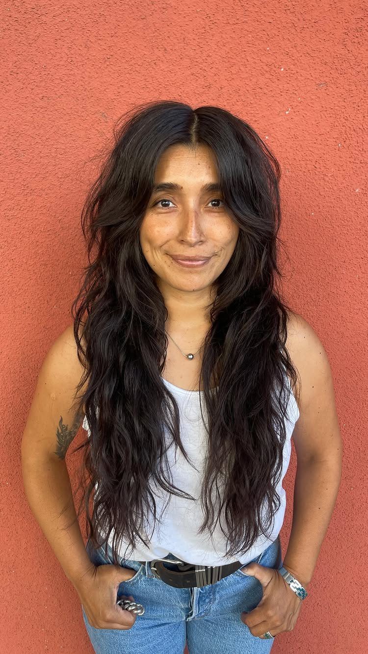 Woman with long, thick dark shag layers and a center part