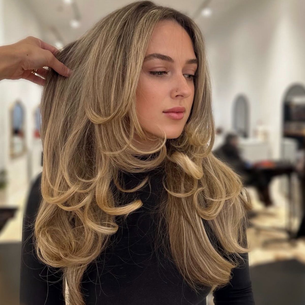 Woman showing a voluminous blonde shag with cascading feathered layers