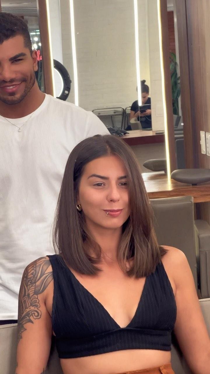 Woman displaying a straight shoulder-length blunt bob haircut in a salon