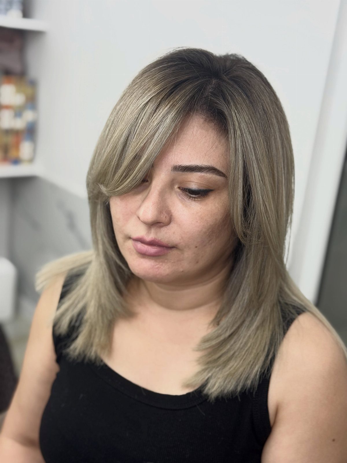 Woman showing a layered shoulder-length bob with sweeping side bangs