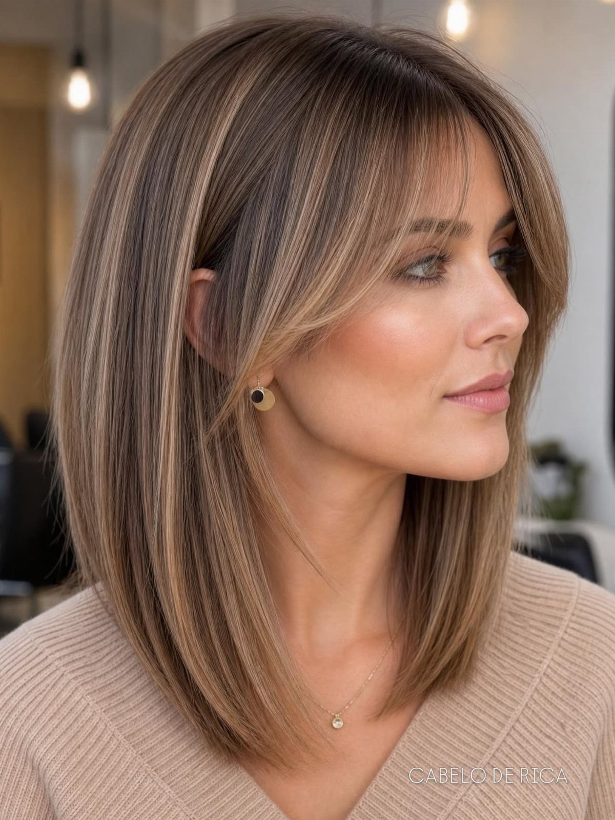 Woman showing shoulder-length highlighted layers with long curtain bangs in a salon
