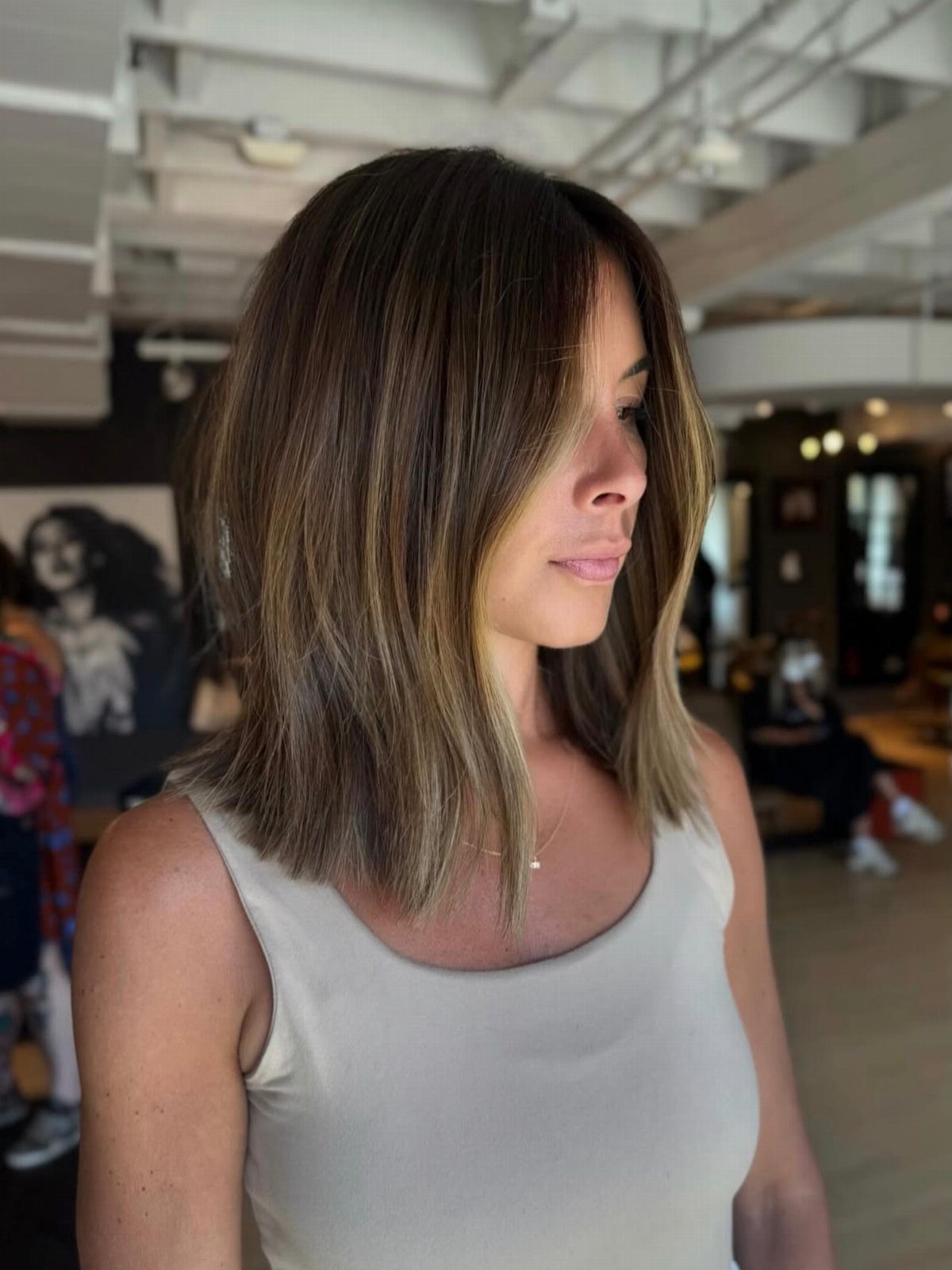 Woman with a straight, shoulder-length layered bob in a salon