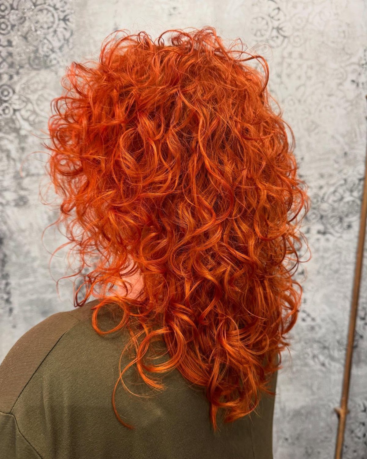 Layered copper curls form a voluminous shoulder-length shag haircut