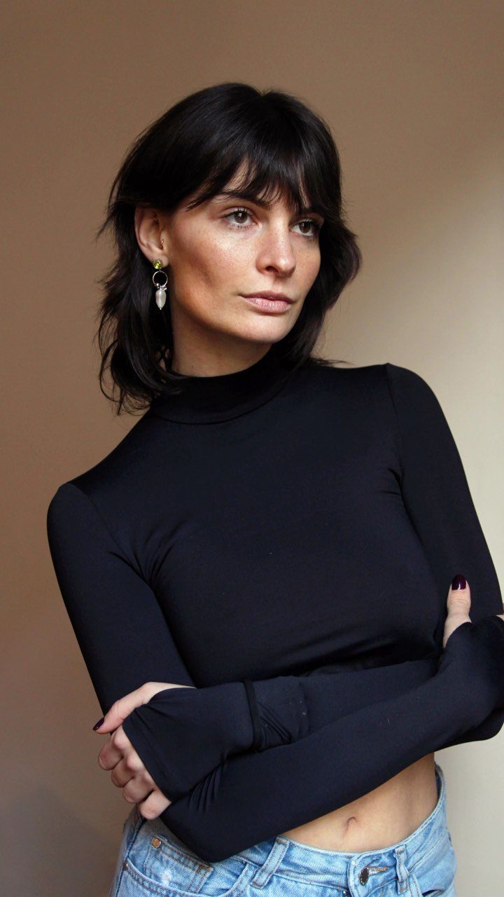 Black choppy layered shoulder-length haircut with wispy bangs