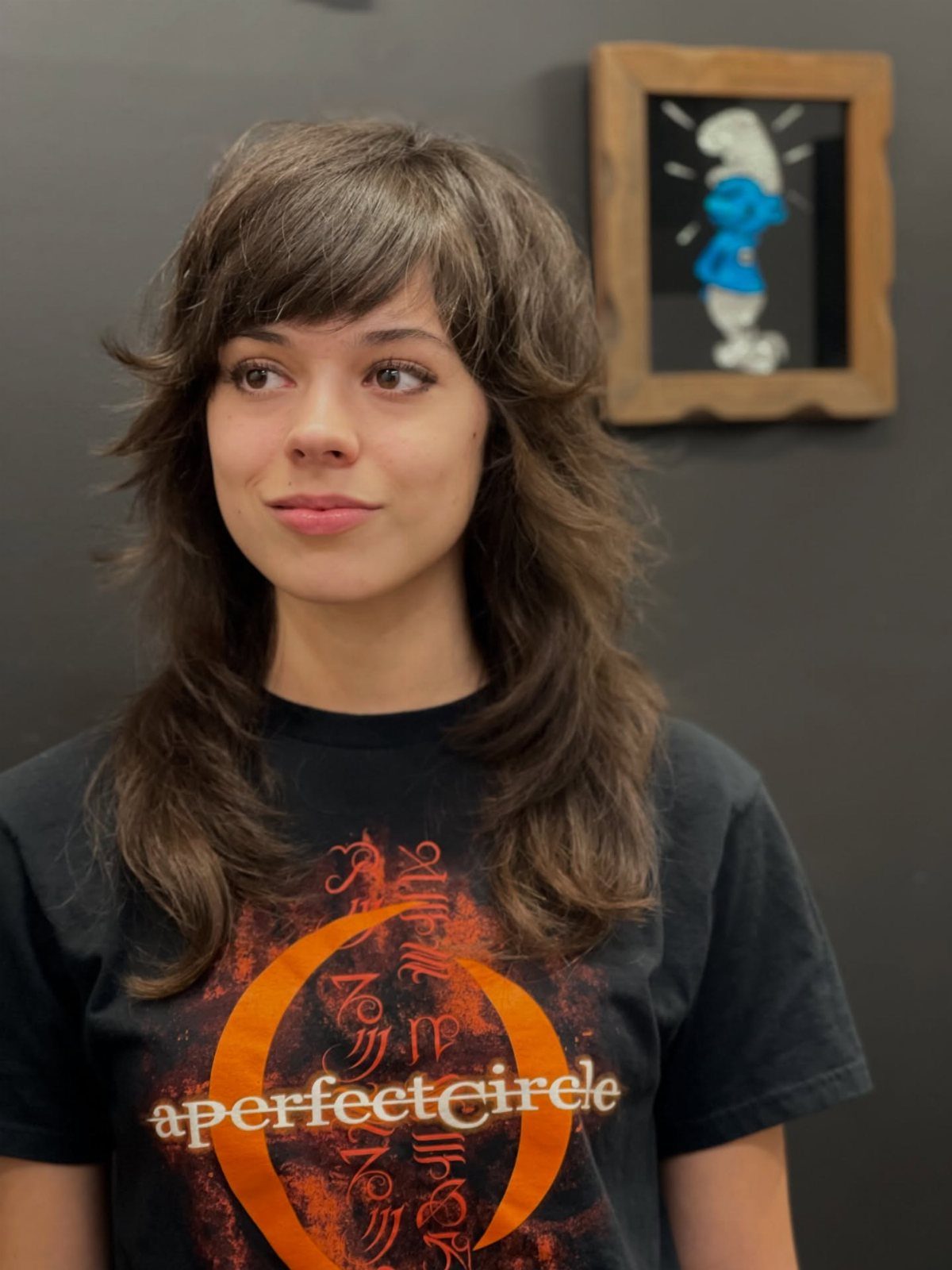 Person with side-parted tousled brown shag haircut and layered waves