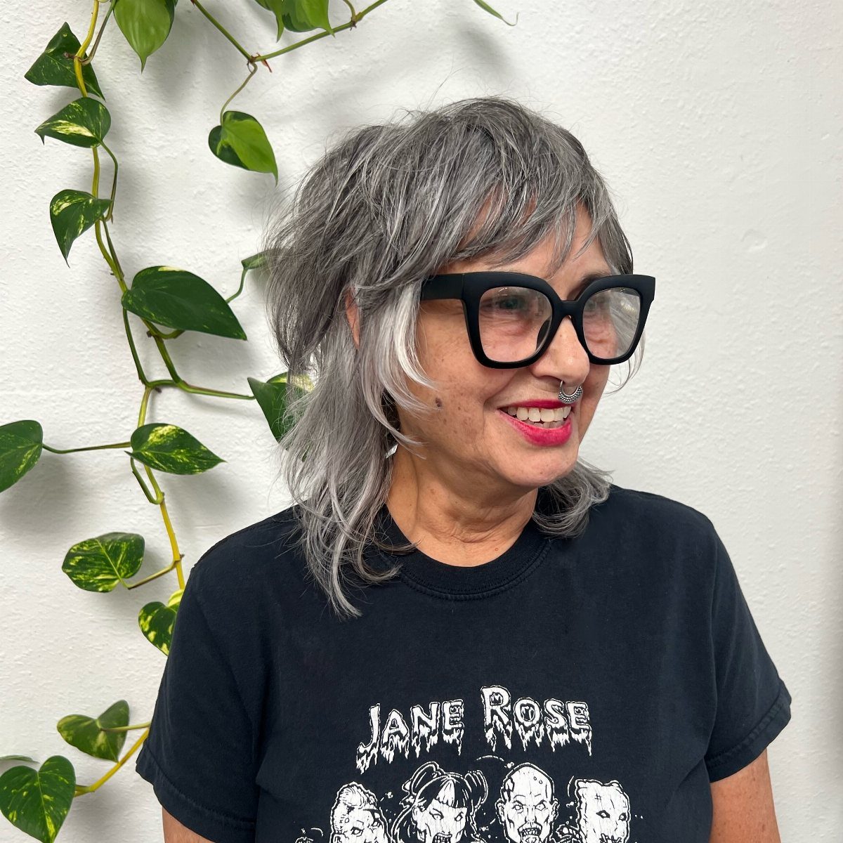 Woman with a layered silver-gray shag haircut and wispy bangs