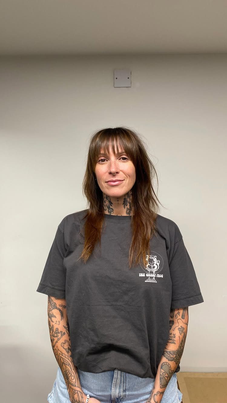Person showing shoulder-length brown hair with wispy face-framing Birkin bangs