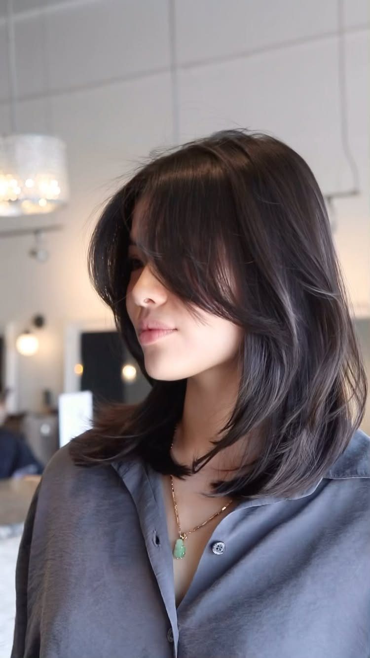 Woman with long dark layered hair and short face-framing pieces
