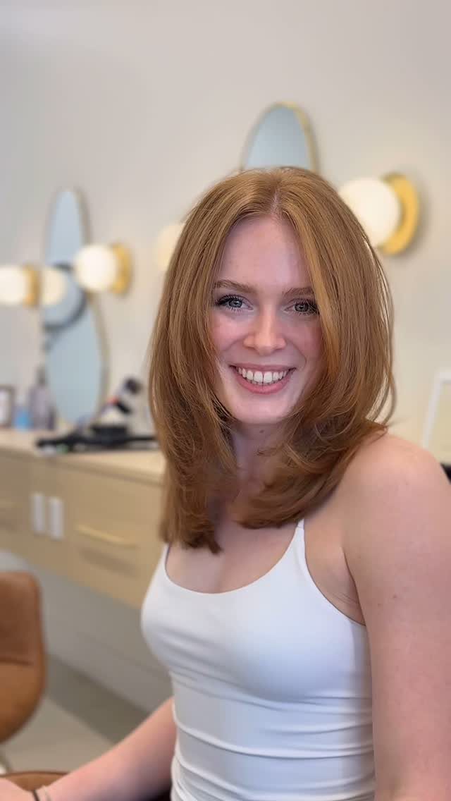 Auburn shoulder-length lob with a center part and softly curved ends