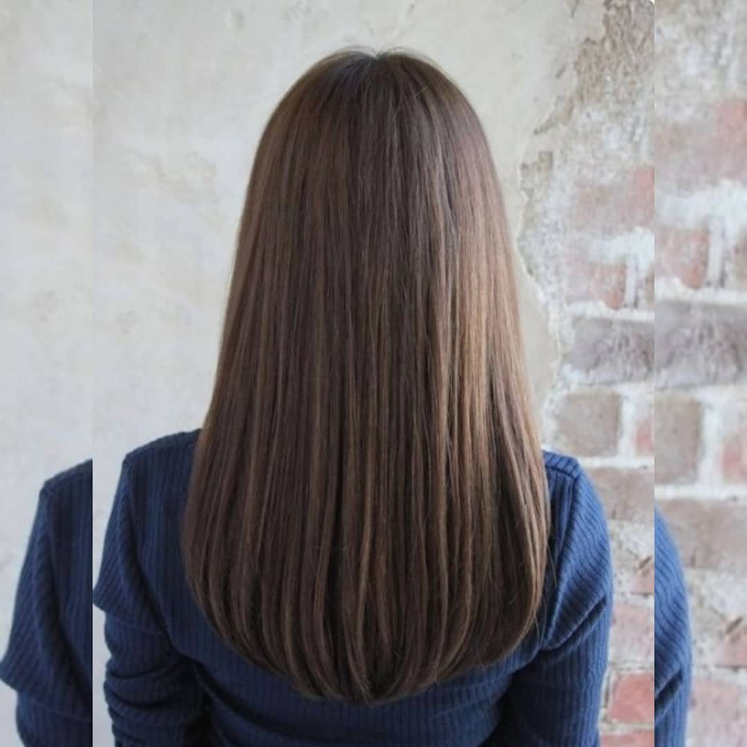 Straight brown hair falls into a gentle U-shaped cut over a navy top