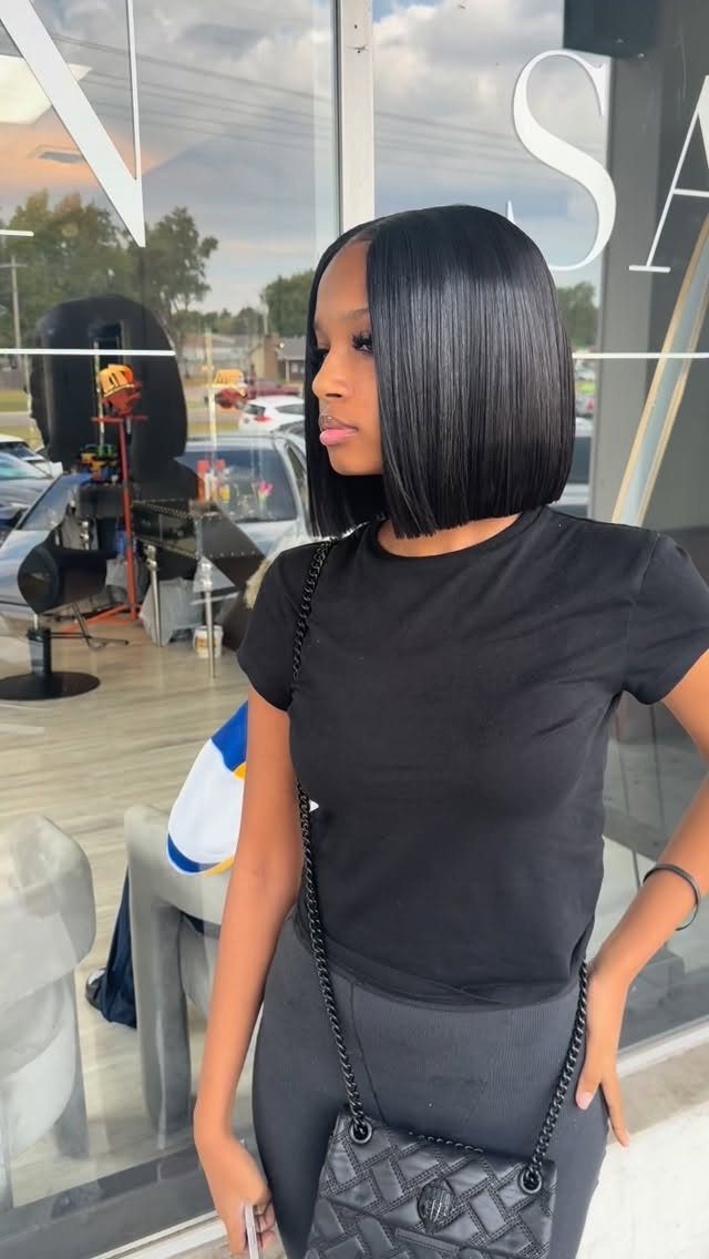 Woman showing a sleek black blunt bob with even jaw-length ends