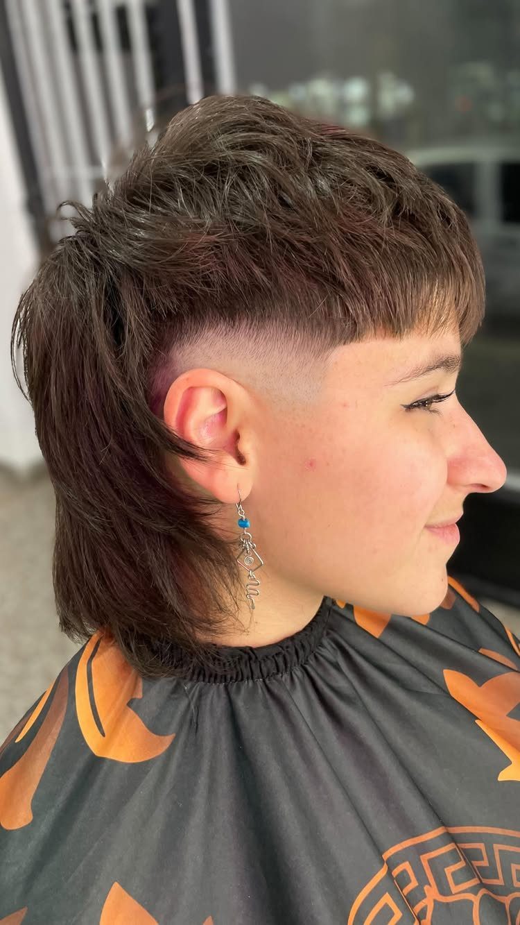 Person with a textured brown modern mullet and closely cropped sides