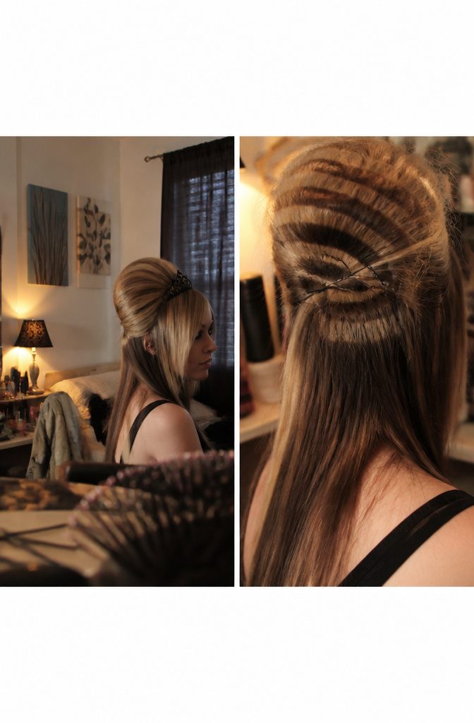 Person with teased hair, side-swept bang, tiara, and heavy black eyeliner