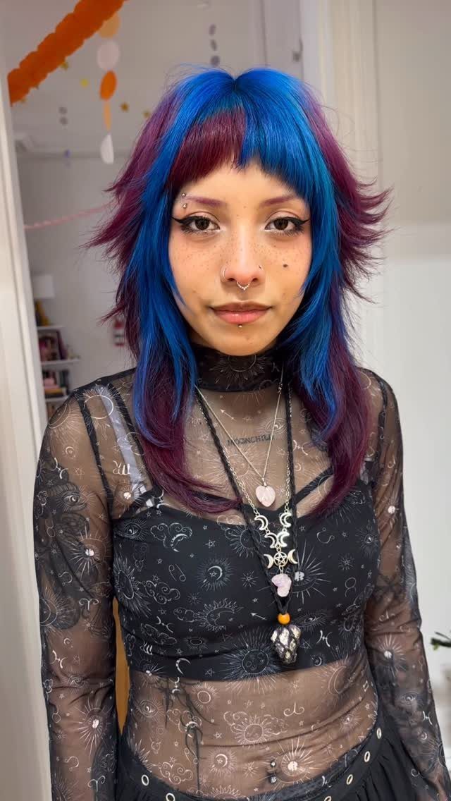 Person with vivid blue and purple shag haircut and blunt fringe