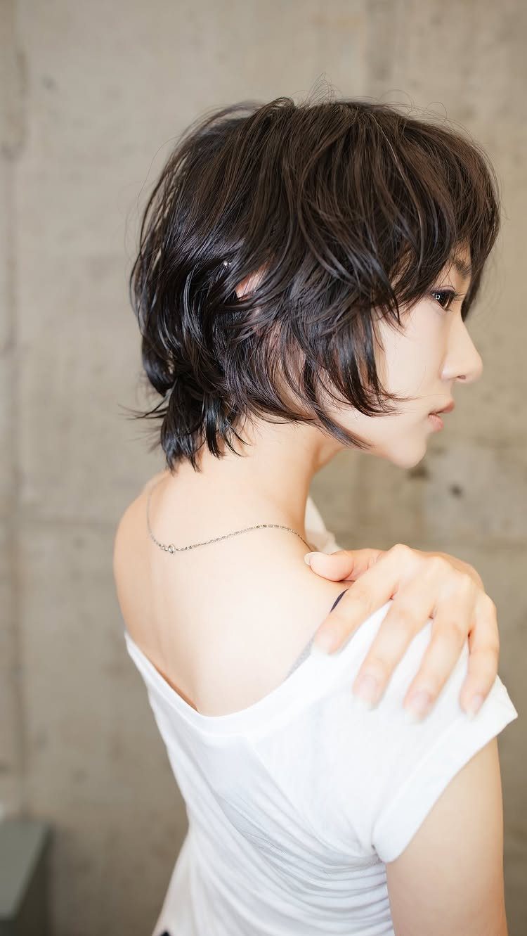 Side-profile person showing a dark short shag with long face-framing bangs
