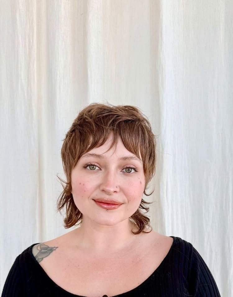 Woman showing short brown shag haircut with piecey fringe and layered sides