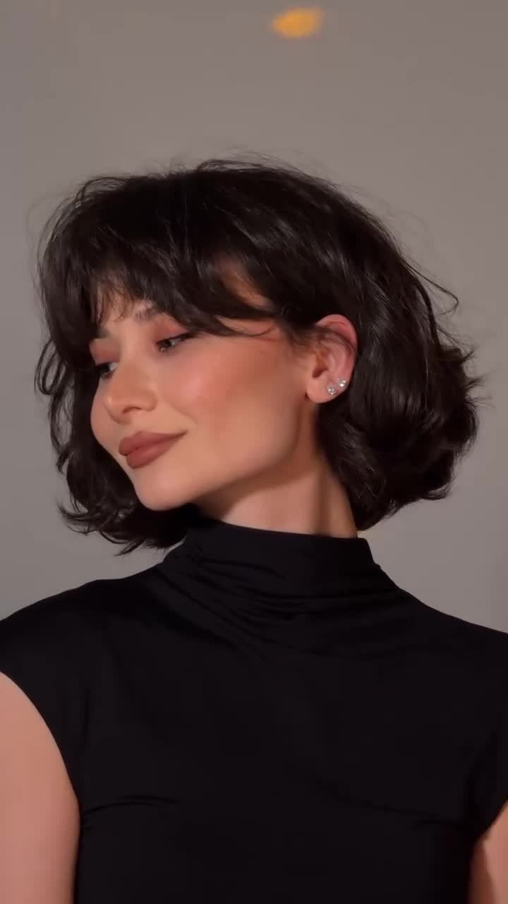 Woman with a dark shaggy bob, choppy layers, and soft bangs