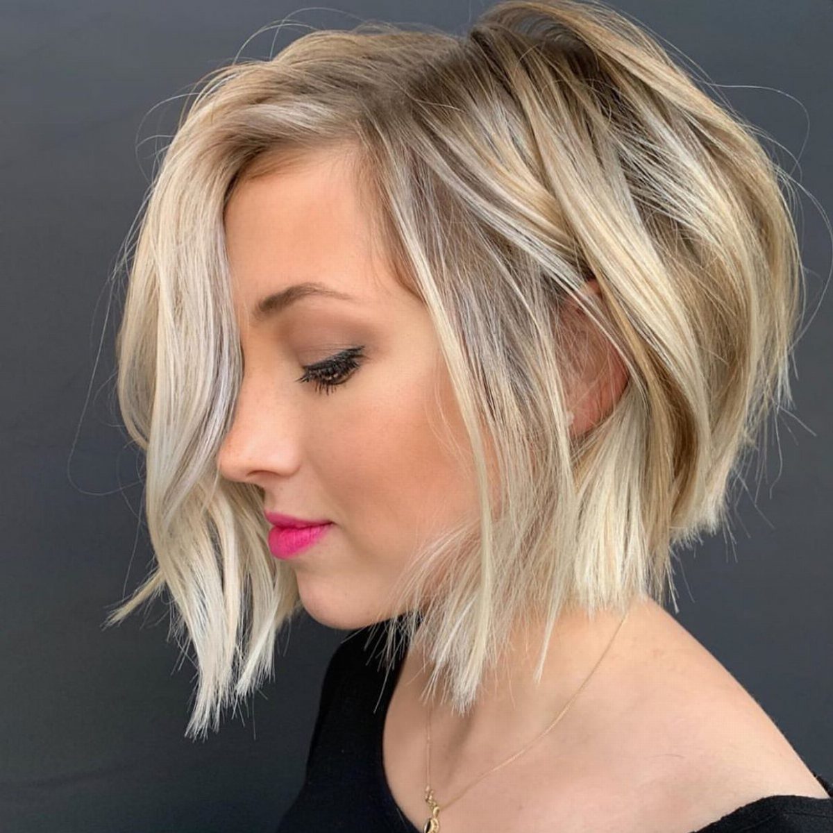 Blonde woman with a short, layered bob angled longer around her face