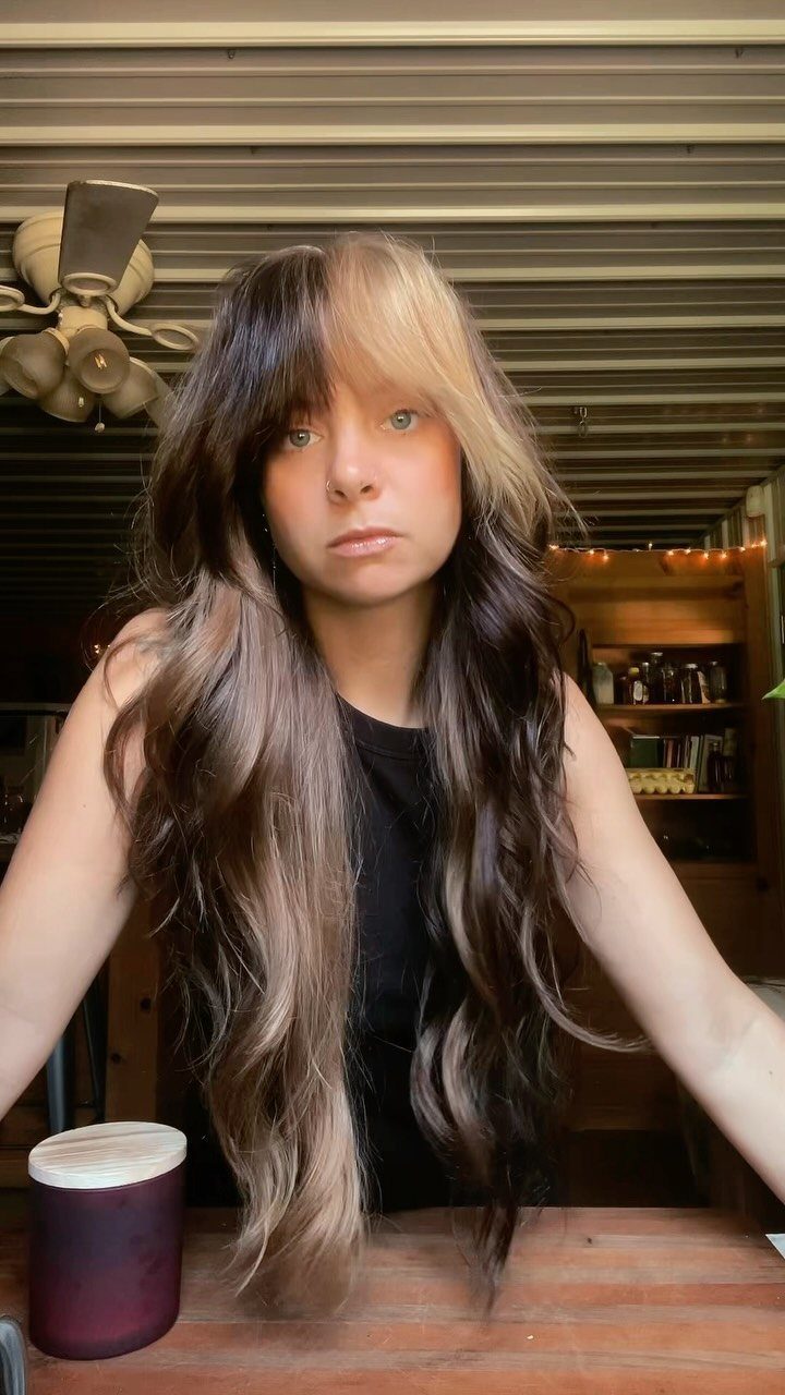 Person with long wavy split-colored dark brown and blonde hair
