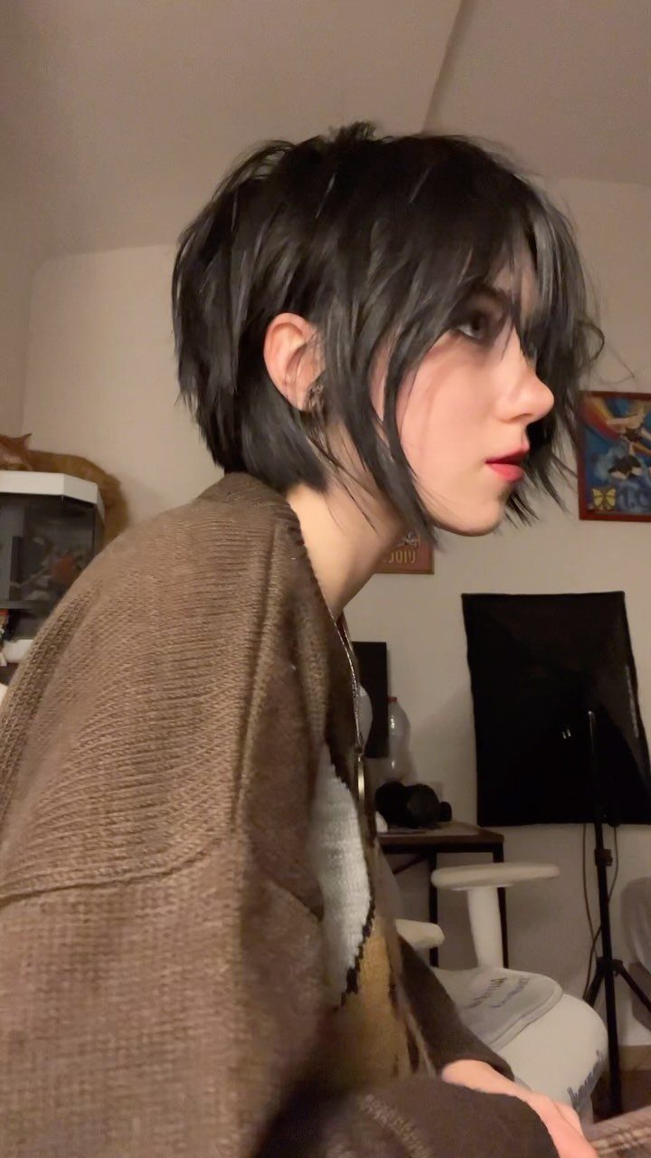 Person with an asymmetrical dark pixie cut and long side-swept fringe