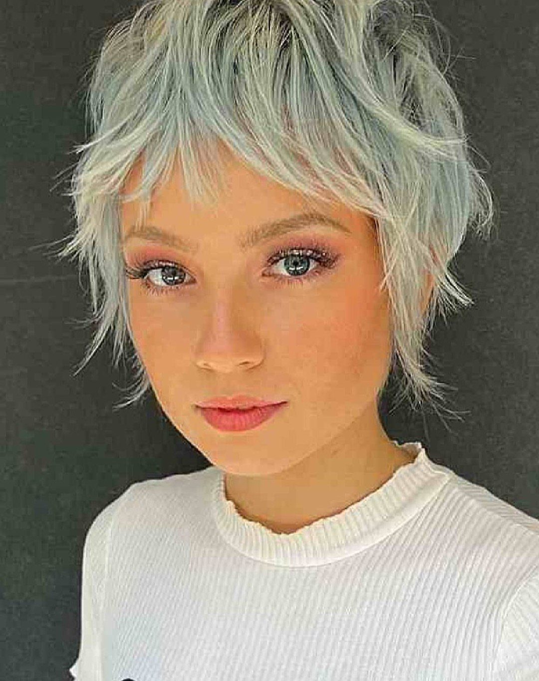 Woman with a silver-blonde pixie shag and separated wispy fringe