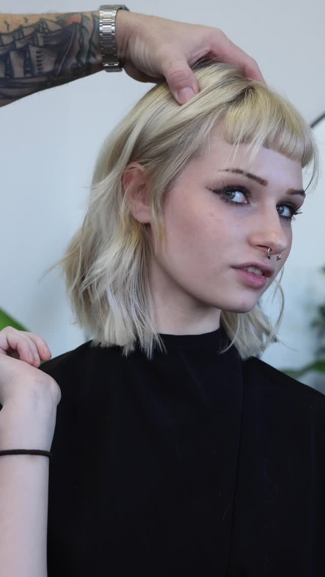 Blonde shaggy bob with choppy layers and short bangs in a salon