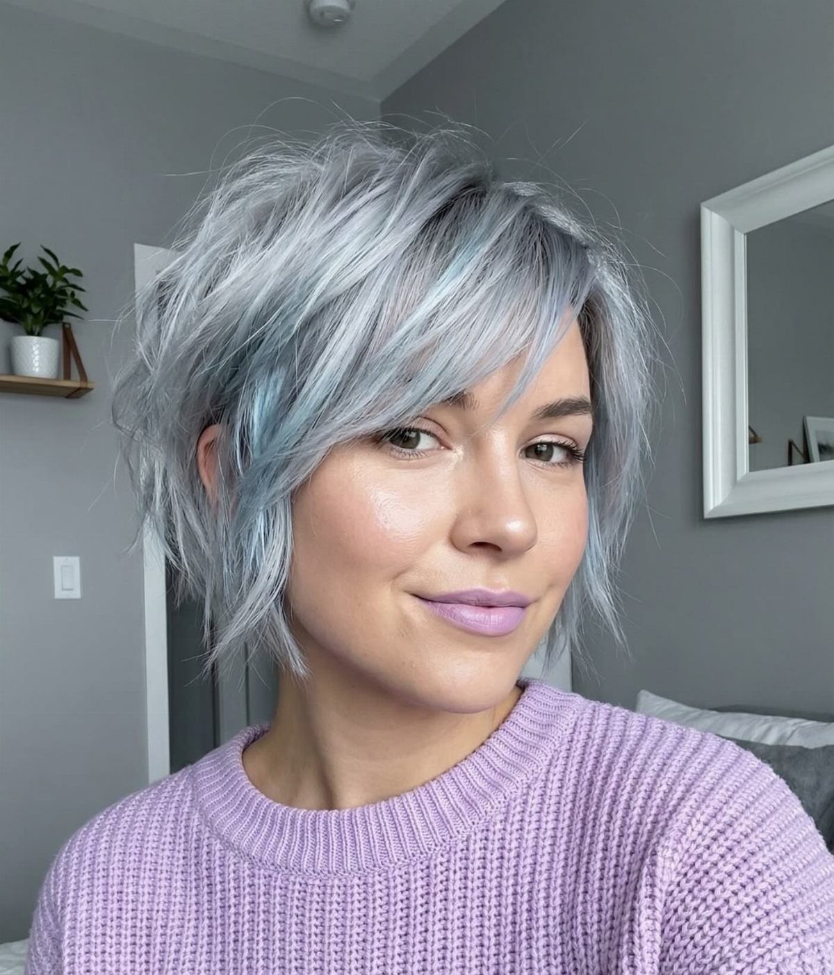 Woman posing with a short silver-white shag haircut and side-swept bangs