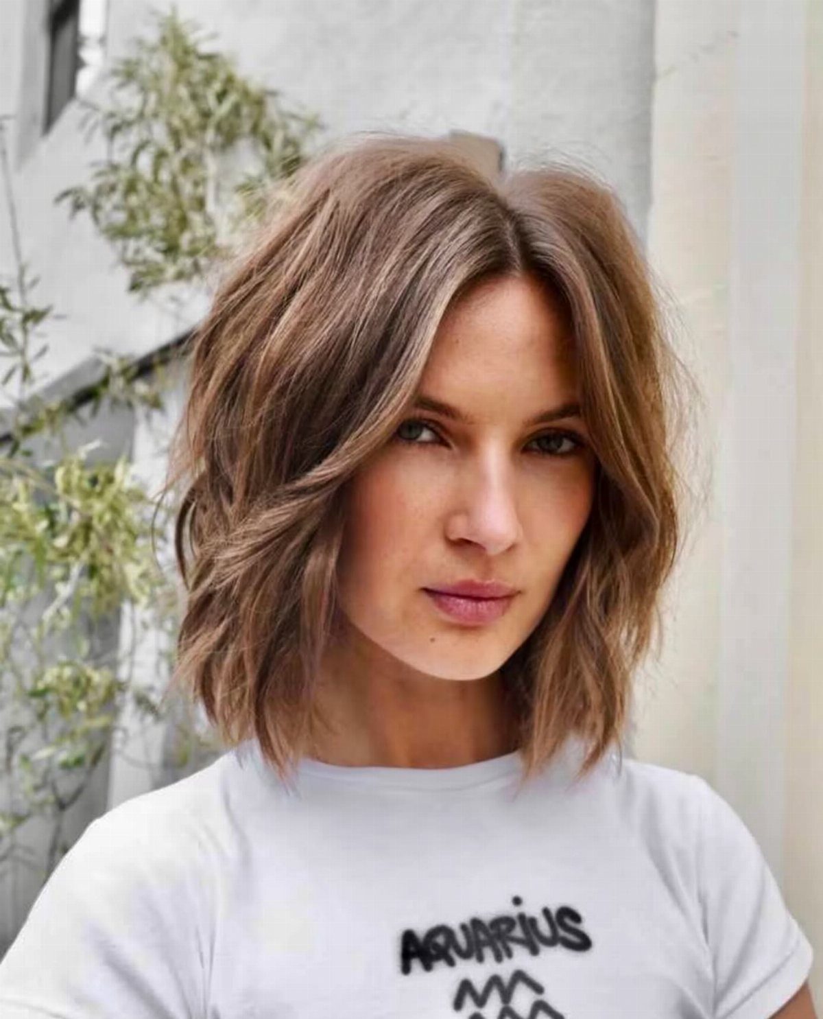 Woman with a smooth, softly layered shoulder-length shaggy bob and center part