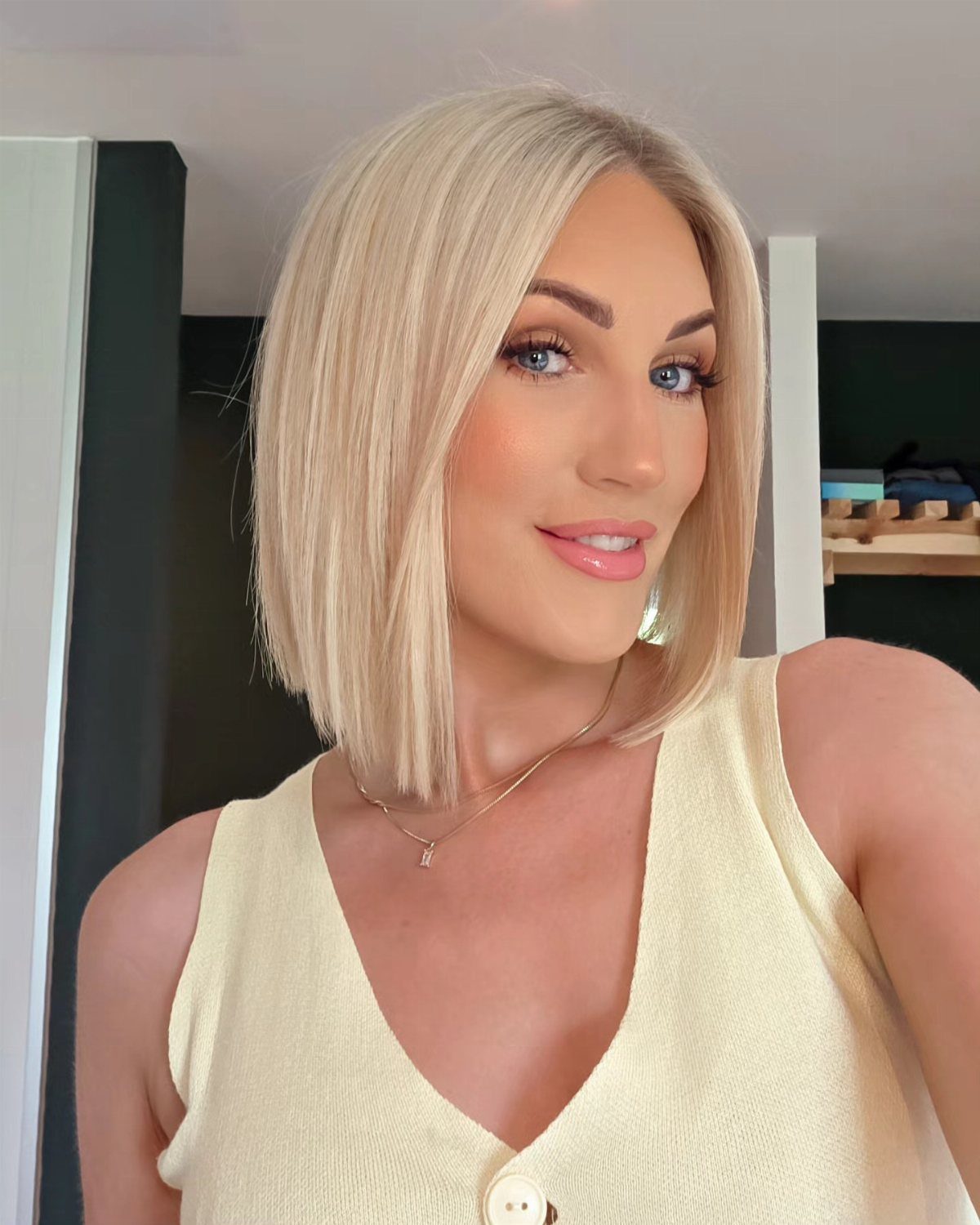Woman displaying a sleek blonde chin-length bob with blunt ends