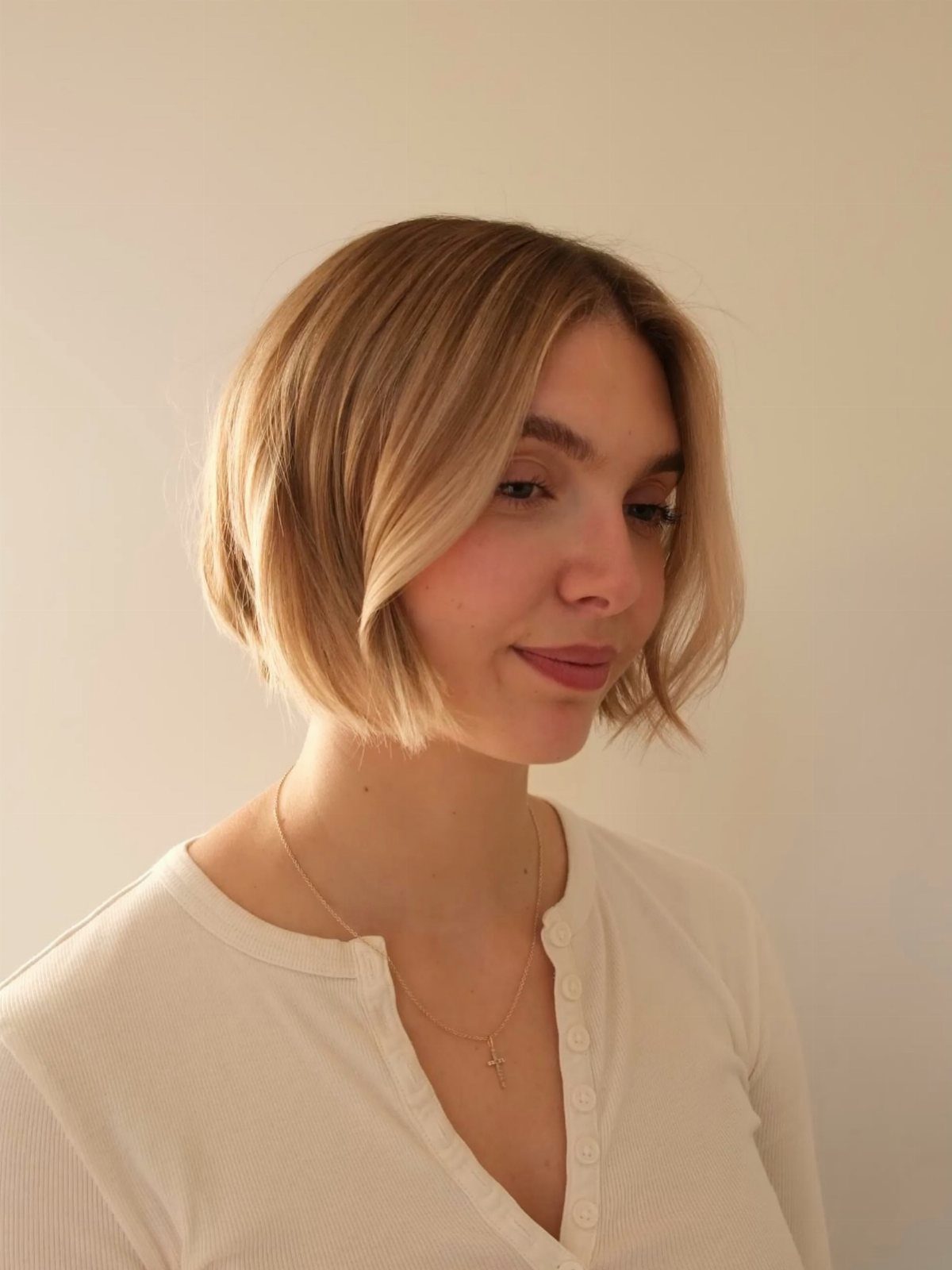 Woman showing a softly layered, chin-length light brown bob