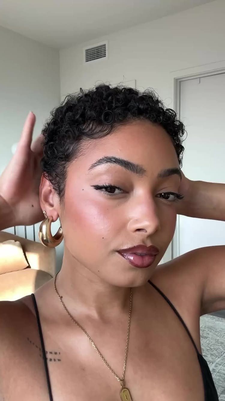 Woman showing a short curly pixie cut with defined natural curls