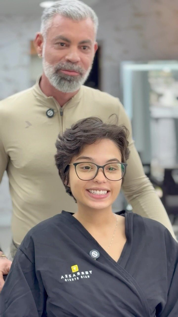 Woman showing a short layered pixie haircut while smiling in a salon
