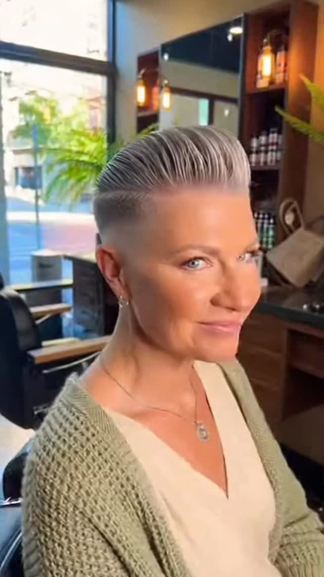 Woman showing a swept-back silver pompadour with closely faded sides in a salon