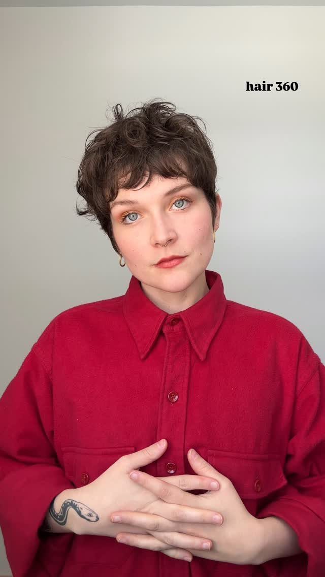 Person models a tousled, layered short haircut with a choppy fringe