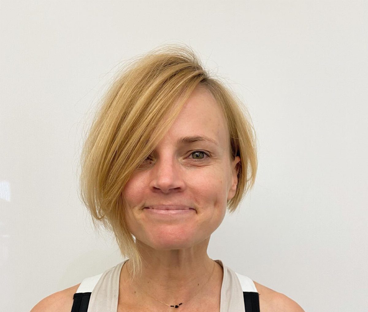 Woman with a short blonde asymmetrical bob and side-swept fringe