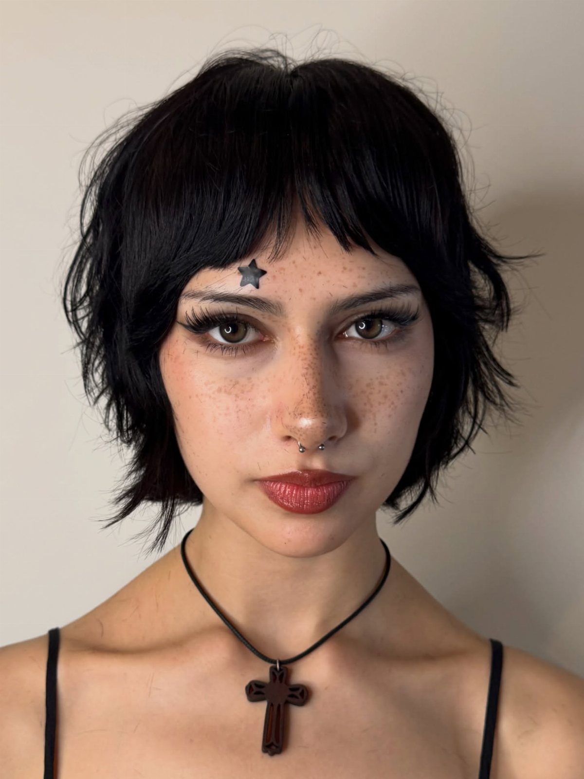 Person with a short black pixie cut and jagged, uneven bangs