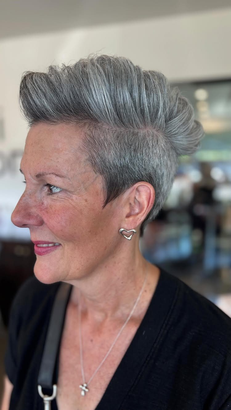 Woman with a silver-gray faux hawk, textured swept-up top and cropped sides