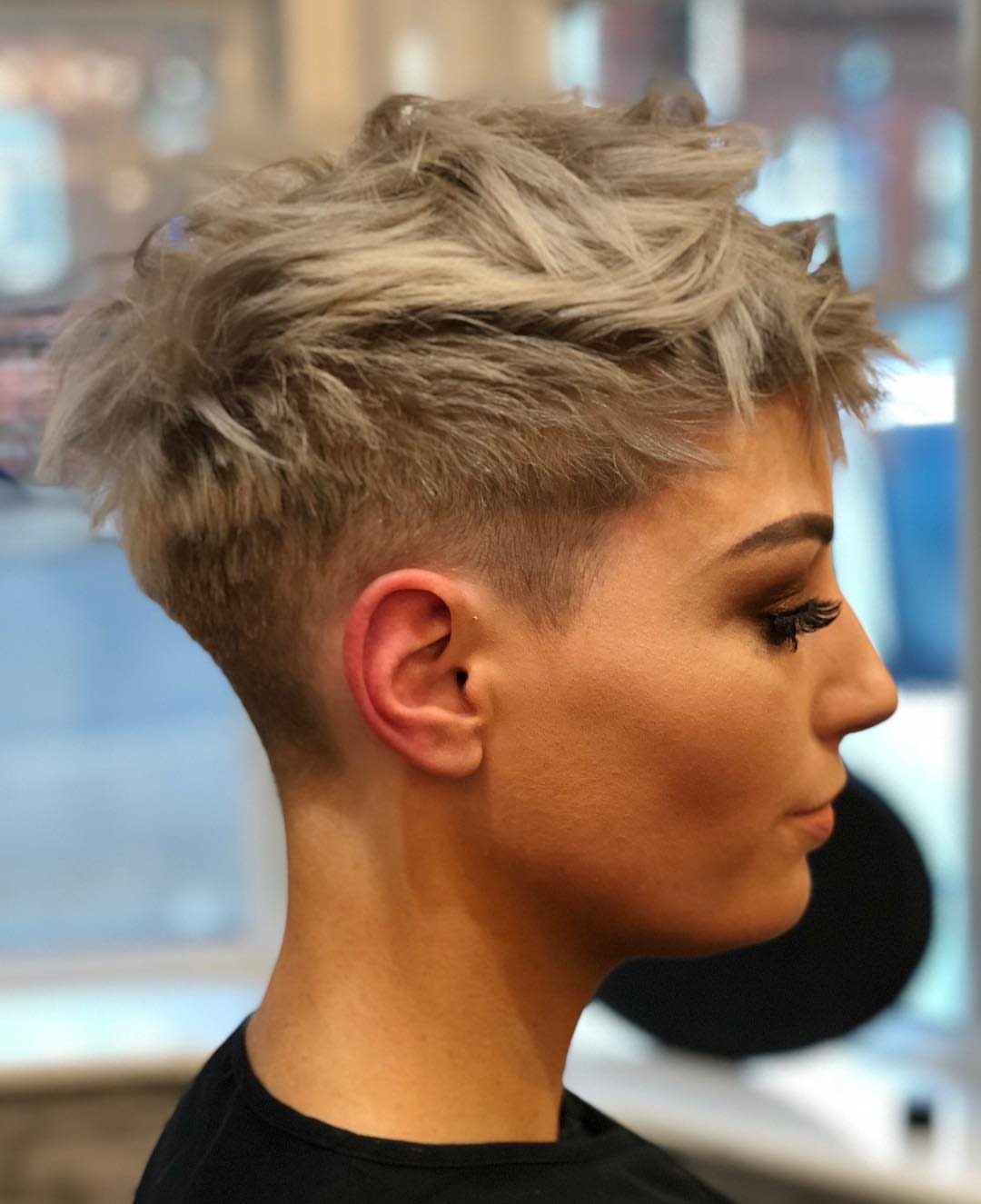 Side-swept blonde pixie with cropped sides and textured volume on top