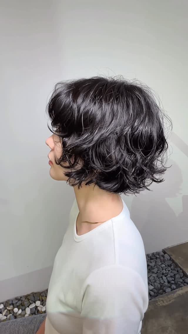 Dark wavy layered bob with bangs shown in side profile