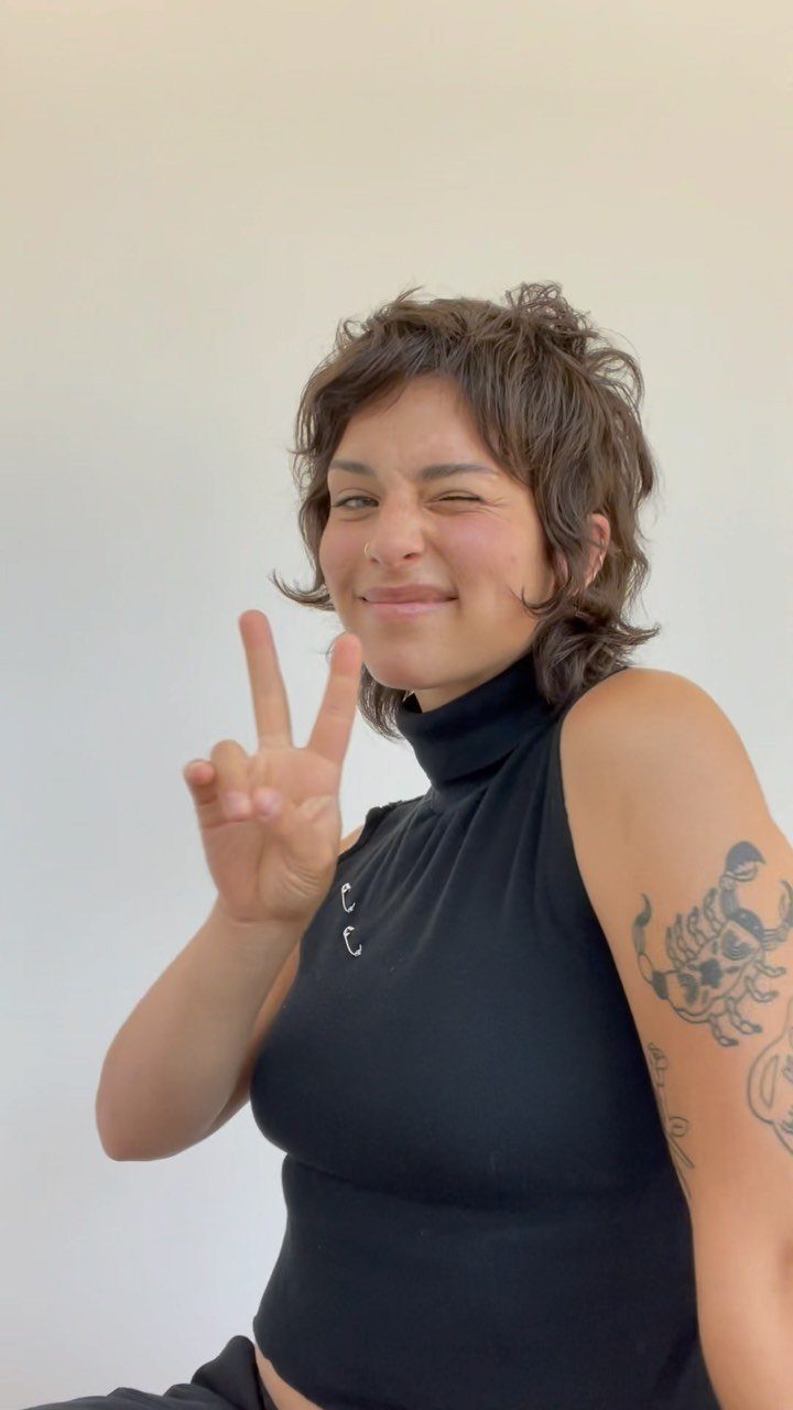 Person showing short curly shag haircut with choppy layers and face-framing fringe